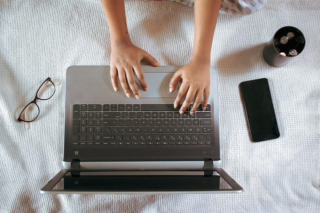 Gadis menggunakan aplikasi di laptop dengan fokus